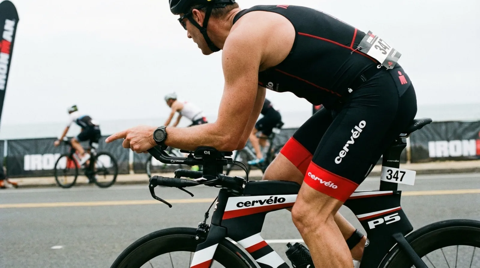 Triathlete on bike checking GPS watch during race