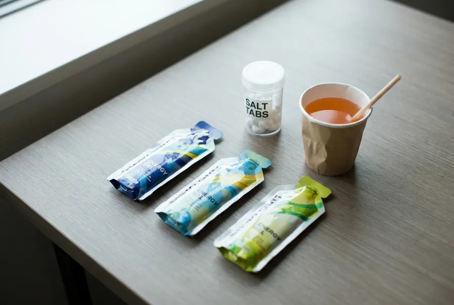 Energy gels, salt tabs, and sports drink nutrition products laid out for an endurance race
