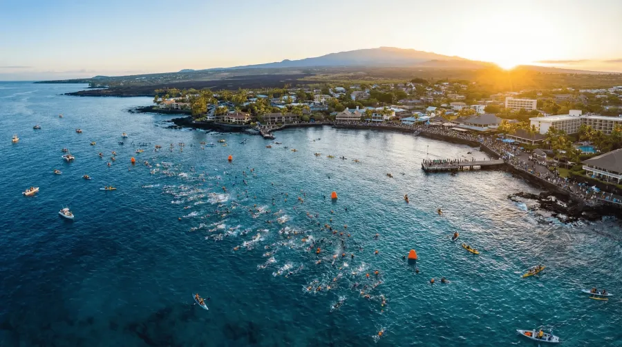 Aerial panoramic view of Kailua-Kona Hawaii during Ironman World Championship swim start with hundreds of athletes in the Pacific