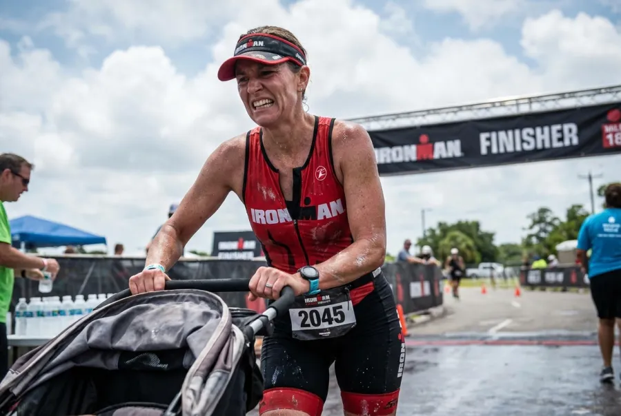 Triathlete pushing through exhaustion at mile 18 of an Ironman marathon with fierce determination