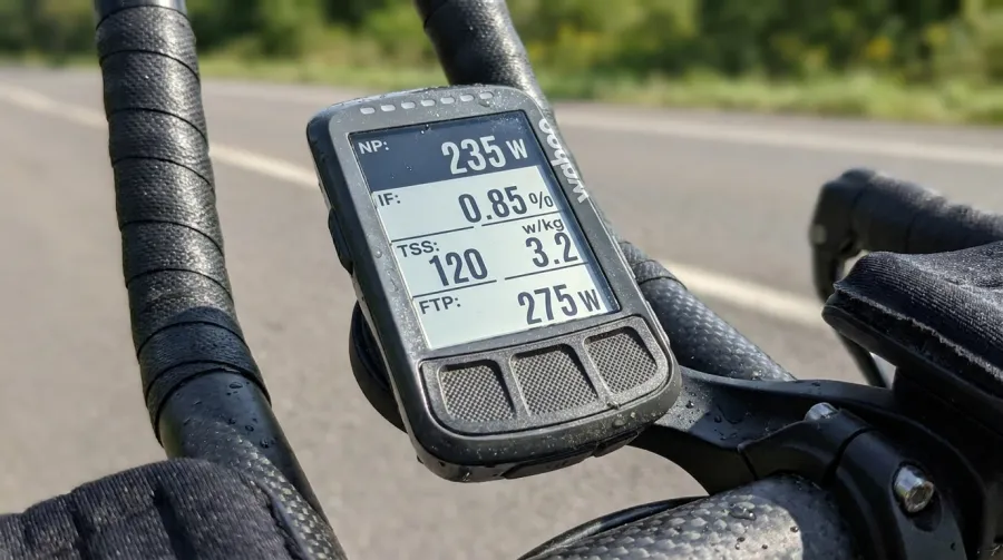 Triathlete checking Garmin Edge 1050 bike computer during training ride