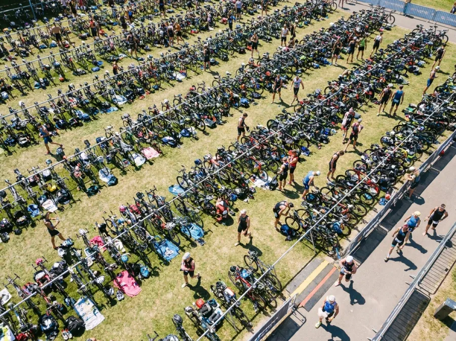 Aerial view of triathlon transition area with bikes racked and gear laid out