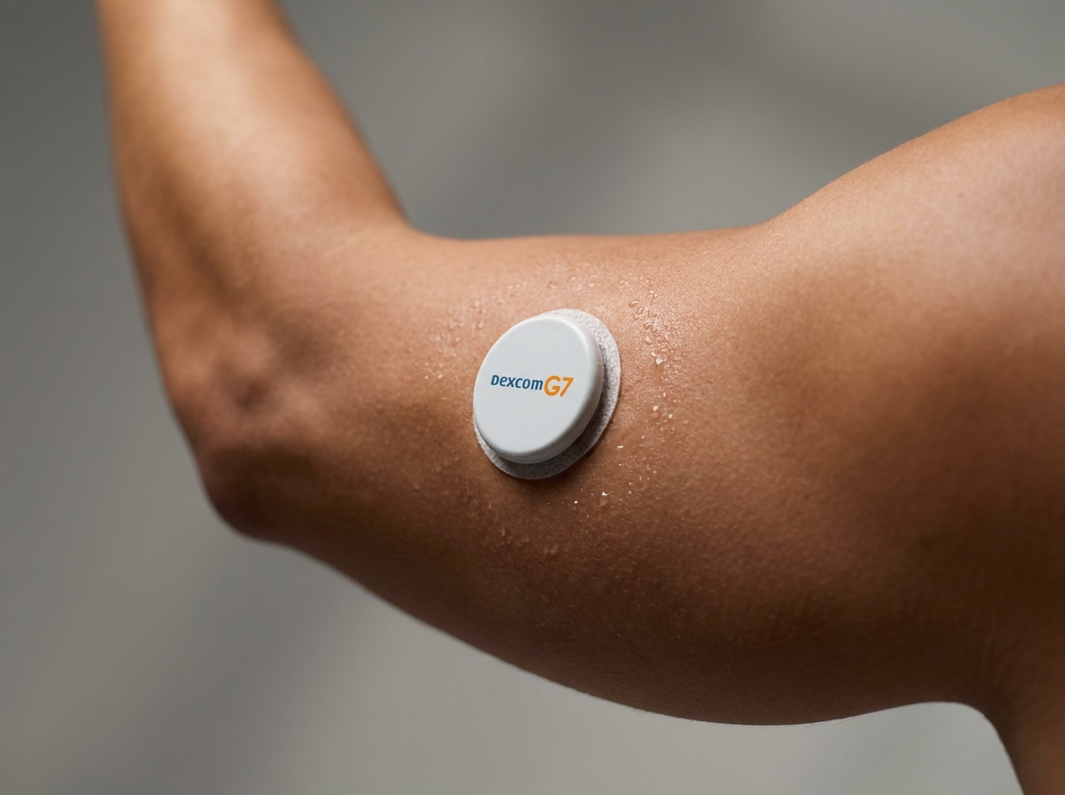 Close-up of a Dexcom G7 CGM sensor on an athlete's upper arm