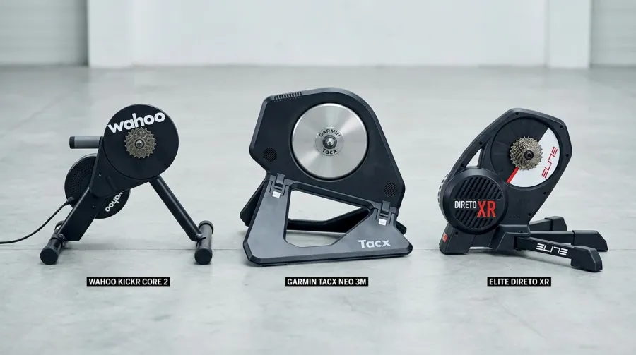 Side-by-side comparison of Wahoo Kickr Core 2, Tacx Neo 3M, and Elite Direto XR smart trainers on gym floor