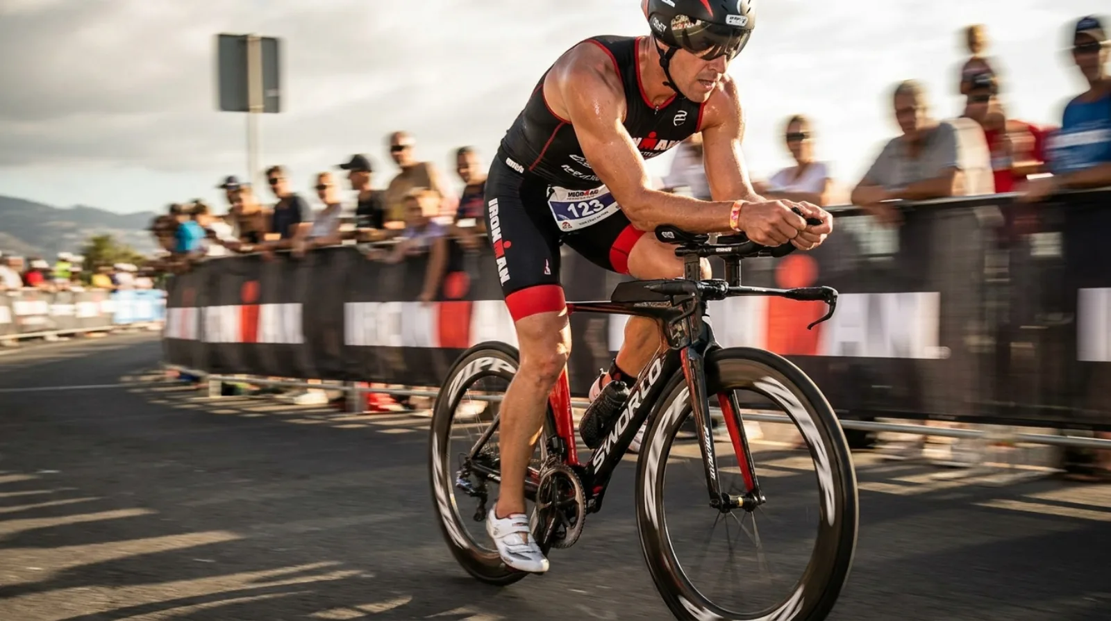 Professional triathlete in aero position on a TT bike racing at an IRONMAN event